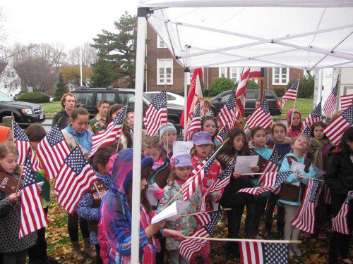 LOCAL GIRL SCOUTS hold flags as they sing the National Anthem at yesterday afternoon’s dedication of the Women Veterans Memorial on Veterans Memorial Common. (Mark Sardella Photo)