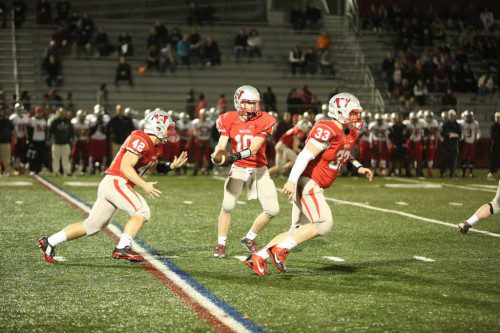 SENIOR QB Ned Buckley (#10) gets ready to hand off the ball to senior RB Paul McGunigle (#42) as senior RB Zack Kane (#33) gets ready to be the lead blocker on the play. The Warriors take on Woburn tonight at Connolly Stadium hoping to earn their second straight win. (Donna Larsson File Photo)