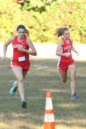SENIOR SARA Custodio (left) and junior Cassie Lucci (right) were two of the seven members of the Warriors’ girls cross country team who competed over the 5K course in the Div. 4 Eastern Mass. championships on Saturday at the Wrentham Developmental Center. (Donna Larsson File Photo)