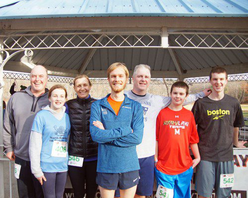 WINNER of the 2015 North Reading 5K Turkey Trot, David Wilson, poses with members of the Keyes Family after the race. The family gives an annual award in memory of the late Fred Keyes, an avid runner and NRHS teacher. From left: Michael Keyes, Catherine Gilligan, age 11, Michelle Keyes, Wilson, Joe Keyes, Brendan and Douglas Keyes. (John Intorcio Photo)