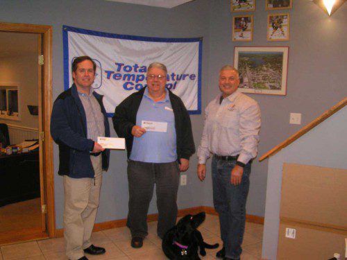 PIERCE AVENUE resident Ken Duval (left) and Gould Street resident Peter Meuse (center) received their prizes from John Ambrosino (right) of Total Temperature Control. The dog lying on the floor is Bella Ambrosino. Duval and Meuse were the Week 9 co-winners of the 54th annual Daily item Football Contest with identical 8-2 records and both won out of over three other entrants due to the tiebreaker. Check out the Daily Item Football Contest again next September. (Jim Southmayd Photo)