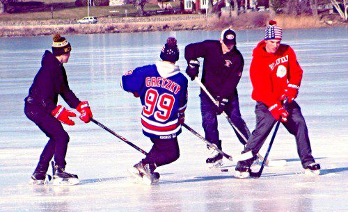 COLD TEMPERATURES returned yesterday making conditions perfect for a game of pickup hockey on Lake Quannapowitt near Veterans’ Field. These young men play for the Warrior varsity team. (Mark Sardella Photo) 