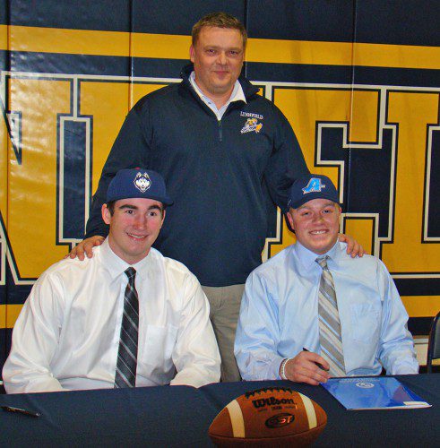 DONNING their new college hats, Cam DeGeorge (left) and CJ Finn (right) flank Pioneer coach Neal Weidman, the man who guided their solid high school football careers for the past four years. (Tom Condardo Photo)