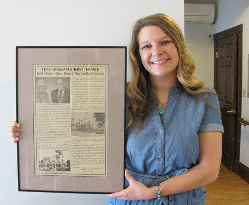 KATE OOSTERMAN, administrator of Oosterman Rest Homes, holds a framed newspaper article citing the Rest Home's 50th Anniversary.