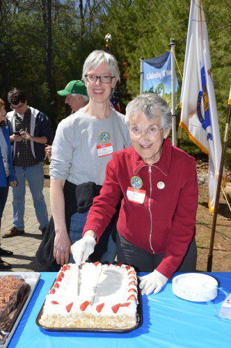 HAVE A PIECE OF CAKE. Pat Keck, (left), President of the Friends of Harold Parker and Beth Thomson, also of the Friends, cut the 100th anniversary birthday cake for Harold Parker State Forest at Saturday's celebration. (Bob Turosz Photo)