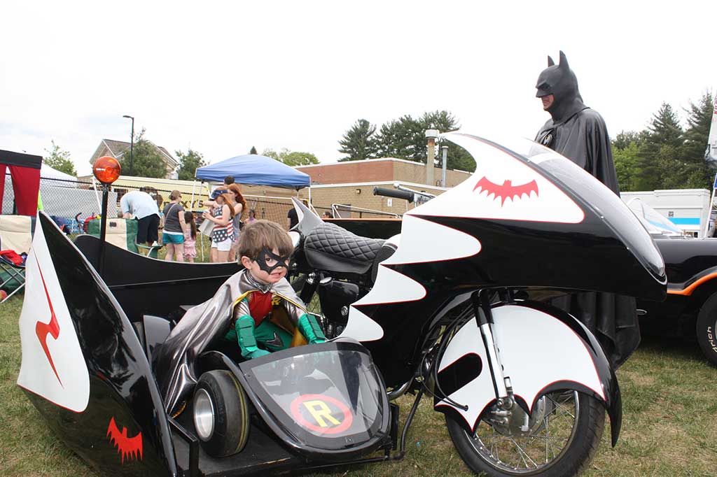 HURRY Batman! The Penguin is on the loose! Asher Donahue, 3, has fun pretending to be Batman's sidekick, Robin, riding in the sidecar of the Batcycle at Townscape's Kids Day activities on May 21. (Maureen Doherty Photo)