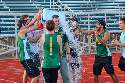 SURPRISE. Boy’s track coach Ryan Spinney receives a victory shower after his team clinched the regular season CAL championship. (John Friberg Photo)