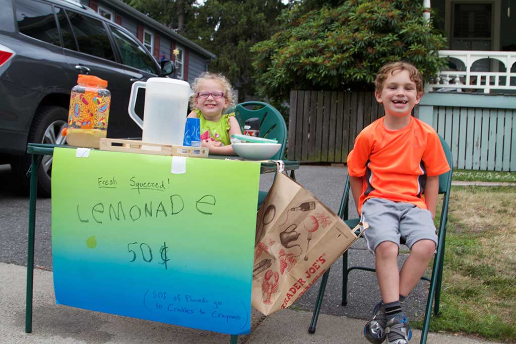 THREE-YEAR-OLD Sophia and 6-year-old Jackson Cormier were all smiles while selling lemonade to thirsty Grove Street residents this week. Proceeds from the lemonade stand were donated to Cradles to Crayons. (Donna Larsson Photo)