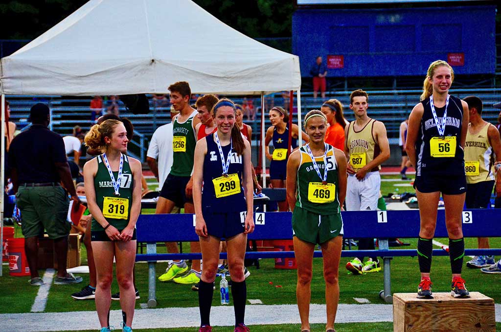 KATE MITCHELL (second from left) poses with her sixth-place medal in the 800m at last week's All-State Meet. After breaking a 15-year-old school record to qualify for All-States, Mitchell bettered her own record by another three seconds (2:14.28) to qualify for both New Englands and Nationals. 
