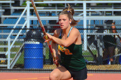 HORNET SENIOR Julia Valenti is the picture of determination on this approach before clearing the bar at 12 feet, four inches to capture the all–state pole vault title. (John Friberg Photo) 