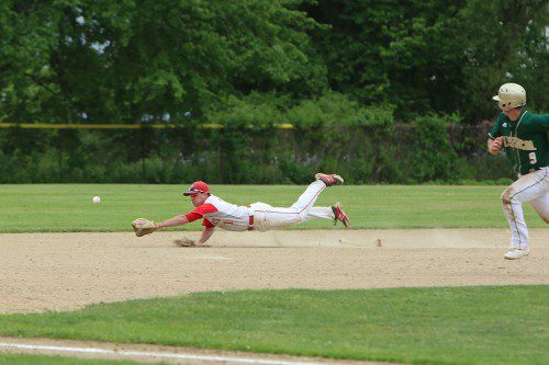 SHORTSTOP TIM Hurley, a junior, dives for a base hit as Matt Lauria (#9) takes off from second base. Hurley led the Warriors with three hits at the plate, scored two runs and knocked in a run. (Donna Larsson Photo)
