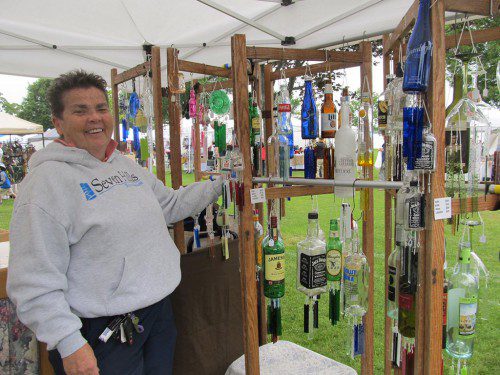 ANN TORREY, owner of The Crafty Peddler, was selling unique wind chimes made from beer, wine and nip bottles at the Festival by the Lake. (Gail Lowe Photo)