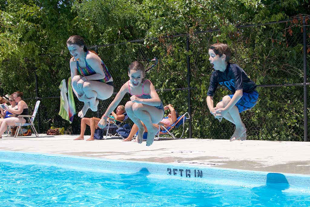 SIBLINGS, from left, Olivia, Alexix and Connor Bates are about to make a splash as they cannon ball into the Lloyd Memorial Swimming Pool Tuesday. (Donna Larsson Photo)