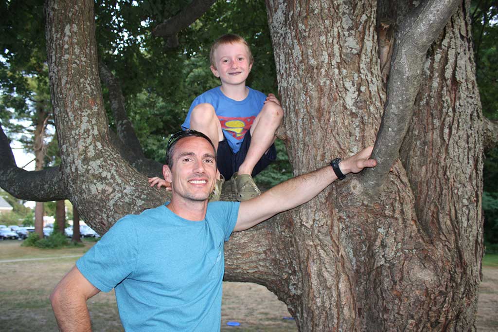 LOCAL RESIDENT Brian Tripp and his 7-year-old son Brady kick back and relax at the Rotary Club’s Concert on the Common July 27. (Dan Tomasello Photo)