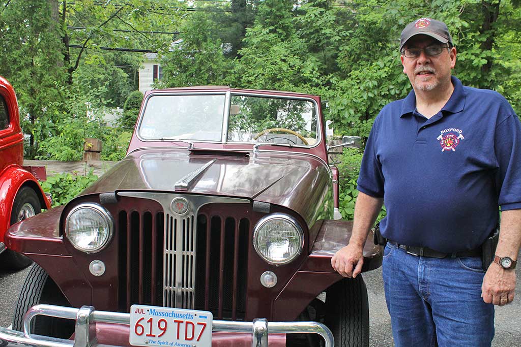 JOHN ROWEN proudly displays his late uncle Arthur Funai’s 1949 Willys-Overland Jeepster at the Senior Center’s Antique Car Show June 28. Funai, who passed away in May, founded the event and lived in town for over 50 years. (Dan Tomasello Photo)