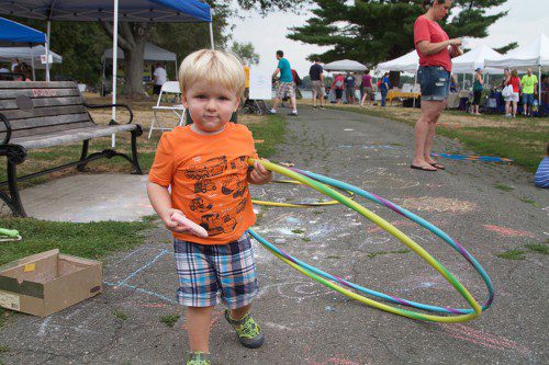NICHOLAS SCHNEEBERG, 2, had many things to do during this weekend's Farmers Market in Hall Park. (Donna Larsson Photo)