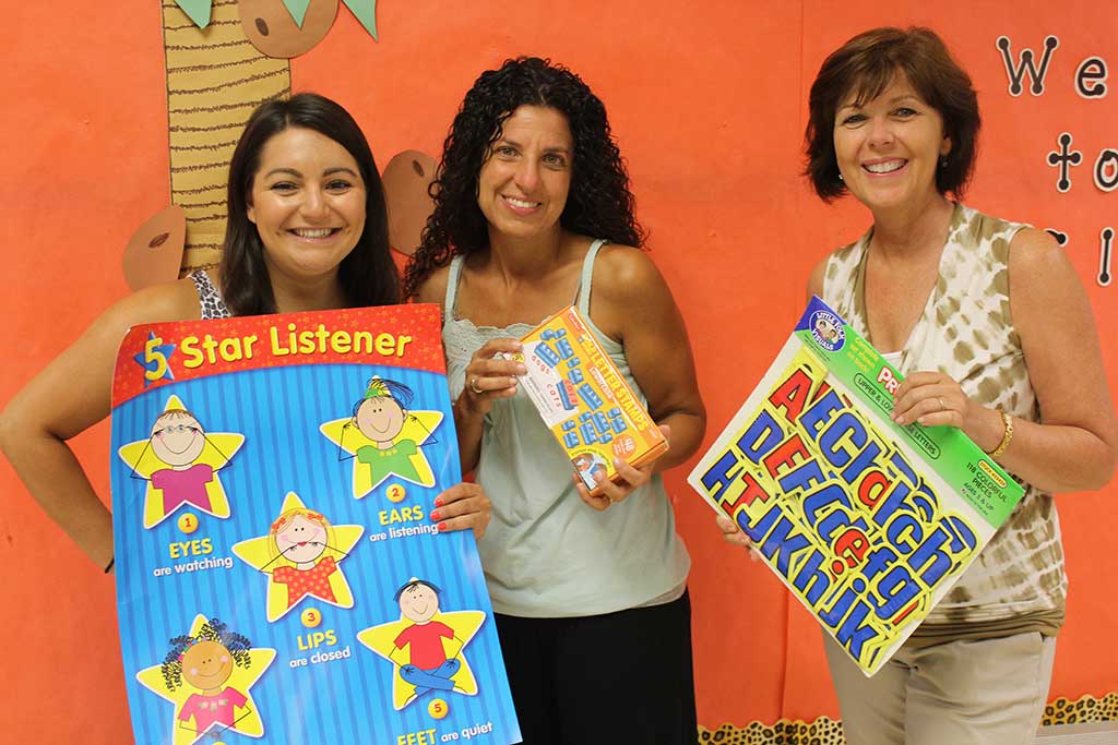 KINDERGARTEN TEACHERS, from left, Emily Bonanno, Maria Ferullo and Lisa Ternullo sort through school supplies while getting their Summer Street School classrooms ready for the first day of school on Aug. 31. (Dan Tomasello Photo)