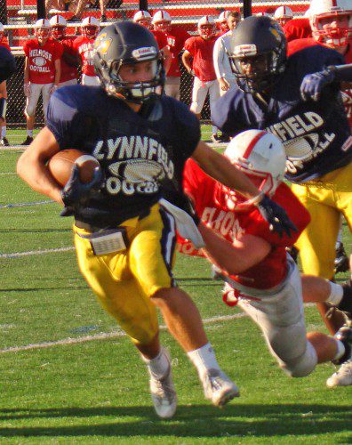 TYLER MURPHY takes on a Melrose tackler en route to a seven-yard gain for the junior in Lynnfield's last preseason scrimmage on Friday. (Tom Condardo Photo)