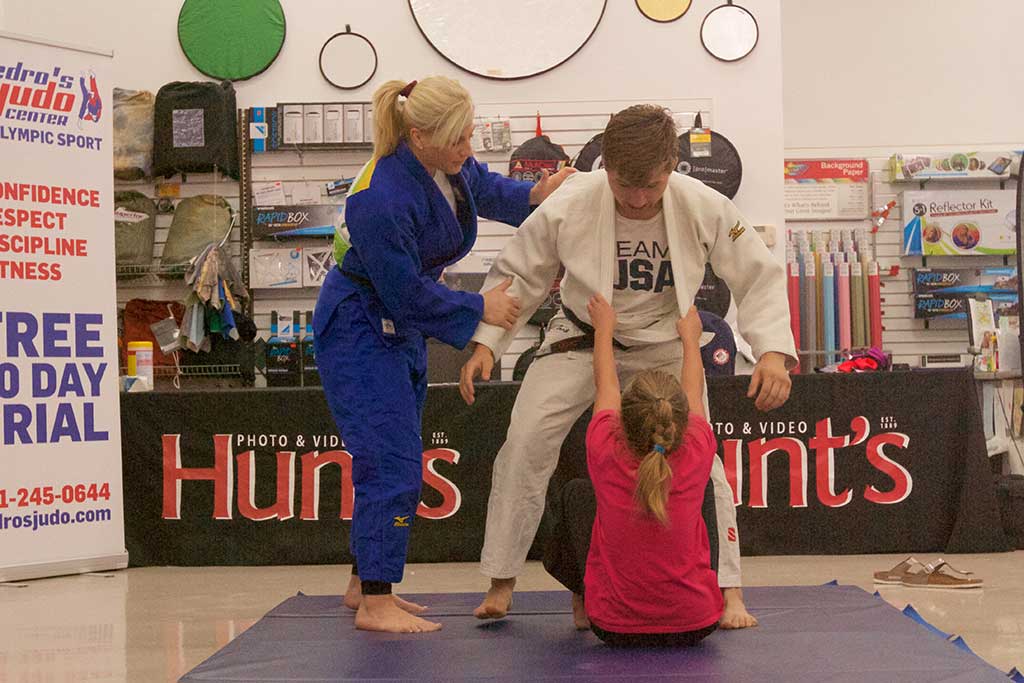 TWO-TIME OLYMPIC judo champion Kayla Harrison (left) shows 9-year-old Fiona Float how to take down an opponent at Hunt’s Photo and Video on Saturday, Sept. 17. Harrison appeared at Hunt’s to promote her Fearless Foundation, which supports victims of childhood sex abuse through education and sports. She has trained for years at Pedro Judo Center on New Salem Street in Wakefield. (Donna Larsson Photo)