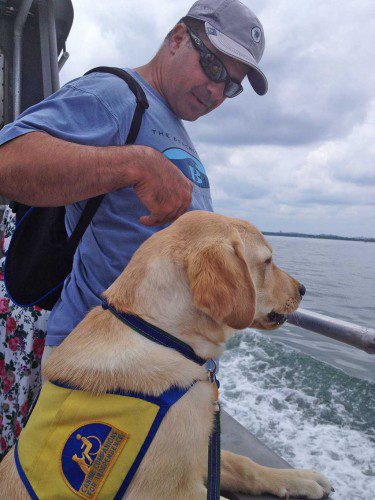 CANINE COMPANIONS FOR INDEPENDENCE puppy raiser John Maffeo is shown with Gary, a golden Labrador retriever mix, on a cruise around Boston Harbor. The organization is a non-profit dedicated to matching service dogs with the disabled. (Courtesy Photo)