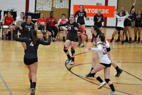 MEMBERS OF the girls’ volleyball team celebrate during yesterday’s match against Lexington. The Warriors defeated Lexington by a 3-1 score at the Charbonneau Field House.