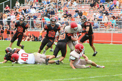 SENIOR RB Joe Marinaccio gets wrapped up by Beverly’s Sam Abate (#20) last Saturday afternoon. The Warriors will be hoping for a better result when they take on Marblehead tomorrow night in the home opener at Landrigan Field. (Donna Larsson Photo)