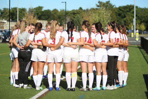 THE WMHS girls’ soccer team huddles together during a recent game. The Warriors broke into the win column last night with a 1-0 triumph over Watertown giving first year head Stephanie Martin her first victory. (Donna Larsson File Photo)