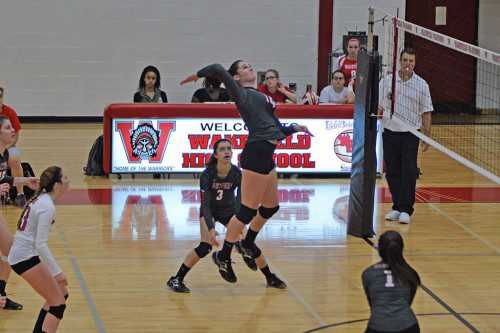 JULIA BROWN, a junior (middle), had 12 kills for the Warriors in their 3-1 triumph over Wilmington last night at the Charbonneau Field House. Teammates Marissa Patti (#3) and Julia Purcell (#1) back her up on the play.
