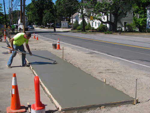 A WORKER applies the finishing touches to a section of new sidewalk on Salem Street. EJ Paving is the contractor doing the work under the town’s supervision. About 1,200 linear feet of new sidewalk is being installed between Chapman Road and the intersection of Salem and Lowell streets. Up to now, there were no sidewalks on either side of that portion of Salem Street. (Mark Sardella Photo)