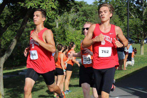 MATT GREATOREX, a junior (left), and Ryan Sullivan, a senior captain, run side by side during yesterday’s meet against Woburn. They captured first and third place with times of 16:27 and 16:43.