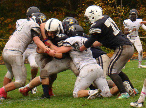 FOOTBALL IS a contact sport. Cooper Marengi (11) and Nathan Drislane (45) sandwich H-W running back Andrew Riccio after a painful one-yard gain Saturday. (Tom Condardo Photo)