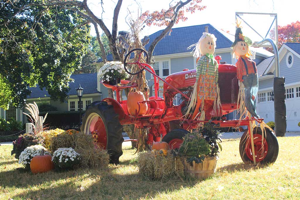 THIS SCARECROW couple prepares for the fall harvest on their Farmall Cub tractor, making Summer Street more colorful. (Dan Tomasello Photo) 