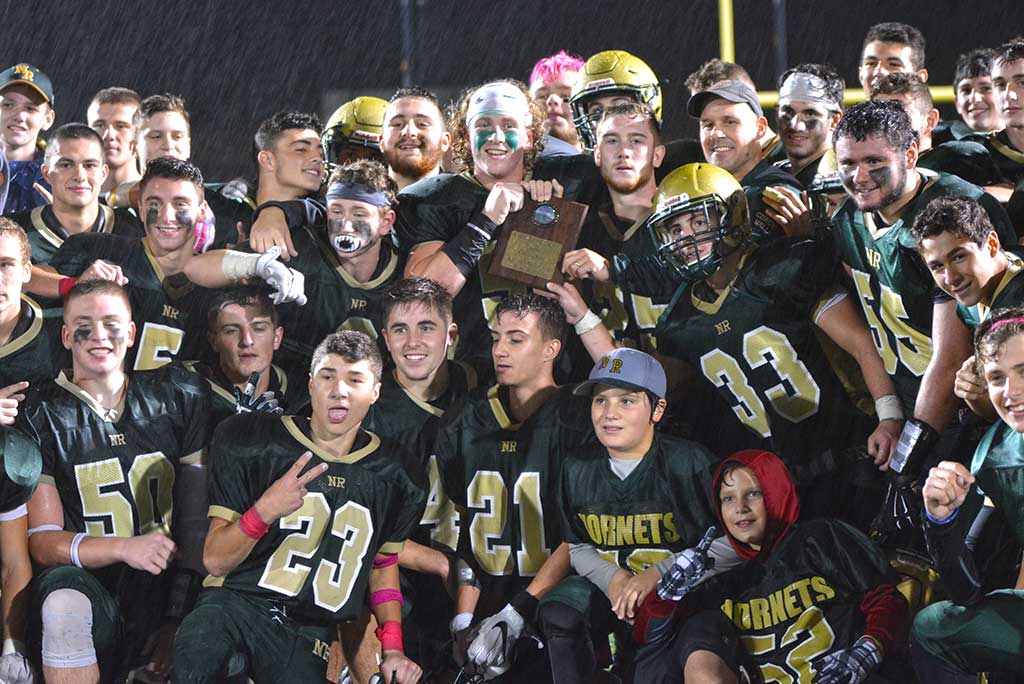 CAL CHAMPIONS. The 2016 NRHS football team displays their first place plaque after winning the Cape Ann League championship for the first time since 1980. Every member on the team, coaches included, was soaked to the skin but jubilant. (Bob Turosz Photo)