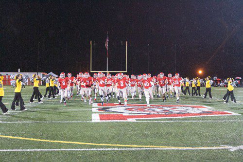 THE WARRIOR football team runs onto Landrigan Field for its game against Wilmington last Friday. Wakefield has an even bigger contest this week when it hosts Stoneham tomorrow night. (Donna Larsson Photo)