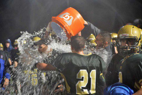 VICTORY SHOWER. NRHS football players soak head coach Jeff Wall with the traditional victory shower as the Hornets won the Cape Ann League championship for the first time since 1980 Friday night. Since the game was played in monsoon–like conditions, Wall was already soaked to the skin at that point anyway. (Bob Turosz Photo)