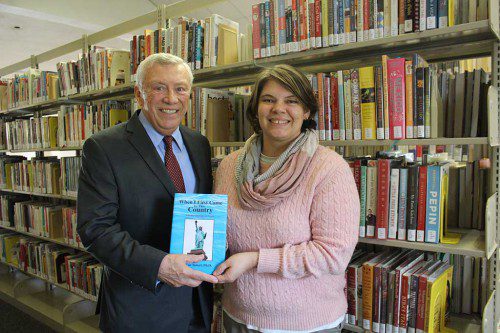 DR. OZCAN TUNCEL (left) presented two copies of his autobiography, “When I First Came To This Country,” to Assistant Library Director Samantha Cabral last week. A native of Turkey who devoted his 40-year career to GE, has resided in Lynnfield with his family since 1978 and was recently presented a Lifetime Achievement Award in Turkey. (Maureen Doherty Photo)
