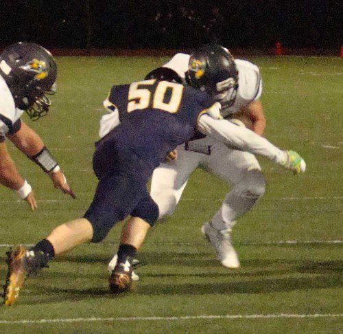 COLLISION course. Lynnfield’s Anthony Murphy (white jersey) lowers his shoulder to gain a few extra yards against the Spartans’ Brendon Donahue (50) in Friday’s Round 2 MIAA playoff game. (Tom Condardo Photo)
