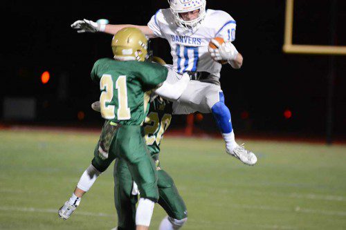 FALCON HUNTING. Hornet defenders Nick Dell Isola, (21) and Tom McHugh (20) combine to bring Danvers running back Matt Andreas down to earth. The Hornet defense stifled Danvers in the second half while the offense ignited for the 35–14 win. (Bob Turosz Photo)