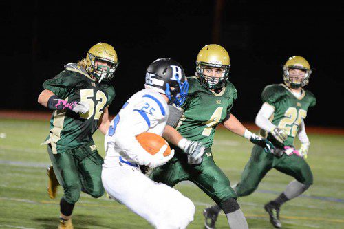 THE HORNET DEFENSE stifled Bedford throughout the game, forcing them to run even when behind in the score. Above, Bob O'Donnell, (52), Bob Donohue, (4) and Matt McCarthy close in on the Bedford running back. (Bob Turosz Photo)