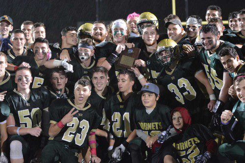 CAL CHAMPIONS. The 2016 NRHS football team displays their first place plaque after winning the Cape Ann League championship for the first time since 1980. Every member on the team, coaches included, was soaked to the skin but jubilant. (Transcript File Photo By Bob Turosz)