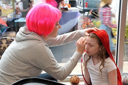 KELSEA KUSA applies some face paint to Riley Pelletier at Vanity Hair in Greenwood Plaza last Sunday. (David Watts Jr. Photo)