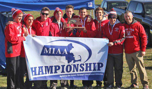 THE Wakefield Memorial High School boys’ cross country team’s performance in winning the MIAA EMass Division 4 state championship helped earn head coach Perry Pappas and junior Matt Greatorex Boston Globe All-Scholastic honors. Members of the team, seen after winning the championship at the Wrentham Developmental Center on Nov. 12, included, from left: Ryan Sullivan, individual champion Greatorex, James Connors, Nick McGee, Jack Stevens, Tommy Lucey, Riley Brackett, Adam Roberto and Pappas. (Meredith Sullivan Photo)