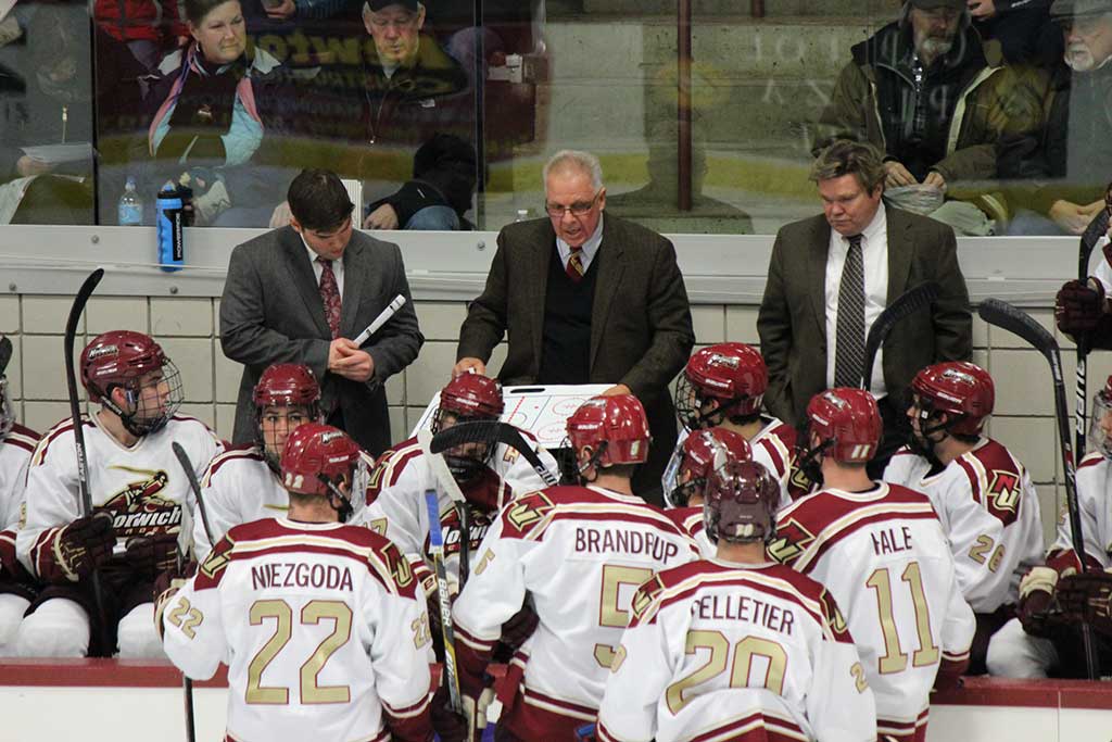MIKE McSHANE, a Wakefield native (center with clipboard), instructs the players on the Norwich University Men’s Hockey team. McShane recently earned his 700th career victory in the Cadets’ 4-0 win over Castleton.