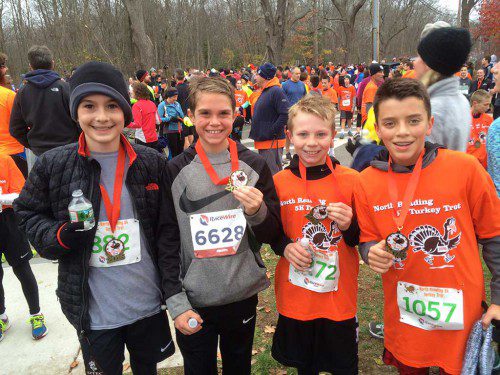 TURKEY TROT RUNNERS Peter Massacotte, Kevin Doble, Liam Rodger, Giovanni Pagliuca show their race medals after finishing the 5K race. (Courtesy Photo) 