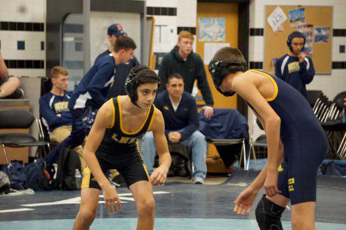 FRESHMAN Chris Metrano (at left) won his first varsity match after pinning his 113 lb. Greater Lowell Tech opponent in 42 seconds during the Black and Gold’s 41-34 victory over Greater Lowell Tech Dec. 21. (Courtesy Photo)