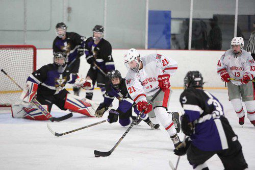 SEAN MCNALL, a senior forward (#21) scored a hat trick to lead the Warriors. McNall scored two goals in the first period and added his third in the final period in Wakefield’s 7-2 win over St. Peter-Marian last night at the Stoneham Arena. (Donna Larsson Photo)