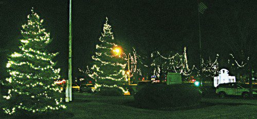 TWO CHRISTMAS TREES light up the lawn in front of Town Hall with the holiday lights and the World War II Monument on Veterans Memorial Common in the background. (Mark Sardella Photo)