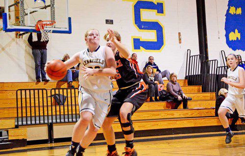 JUNIOR forward Mackenzie O'Neill drives to the hoop against Ipswich while being closely guarded by a Tiger. The Pioneers came close to a win at 55-50. (Courtesy Photo)
