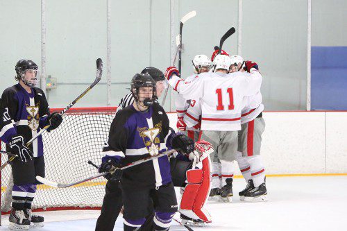 SEVERAL WARRIOR players, including senior defenseman Ben Coccoluto (#11), celebrate after one of the seven goals scored against St. Peter-Marian. Coccoluto scored a goal and had two assists in Wakefield’s 6-2 win over Beverly on Saturday as the Warriors won their second game in a row. (Donna Larsson File Photo)