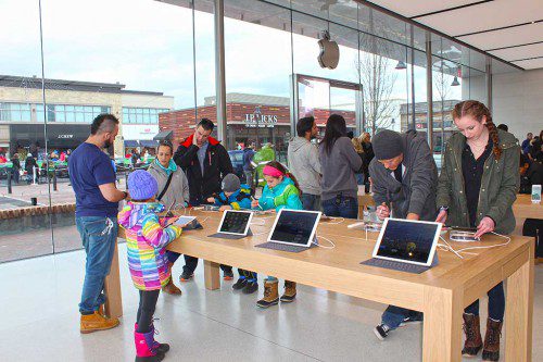 CUSTOMERS of all ages at the new Apple store at MarketStreet Lynnfield were engrossed in trying out the Apple pencil on Saturday. It allows notes to be hand-written on a tablet such as an Apple iPad. (Maureen Doherty Photo)